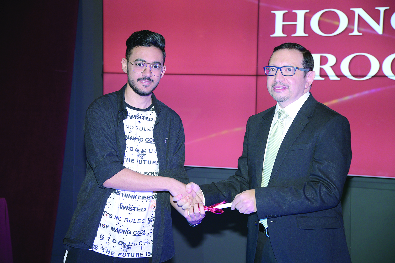 عميد كلية الهندسة والعلوم التطبيقية الدكتور أمير زيد يسلم شهادة التفوق لأحد الطلاب