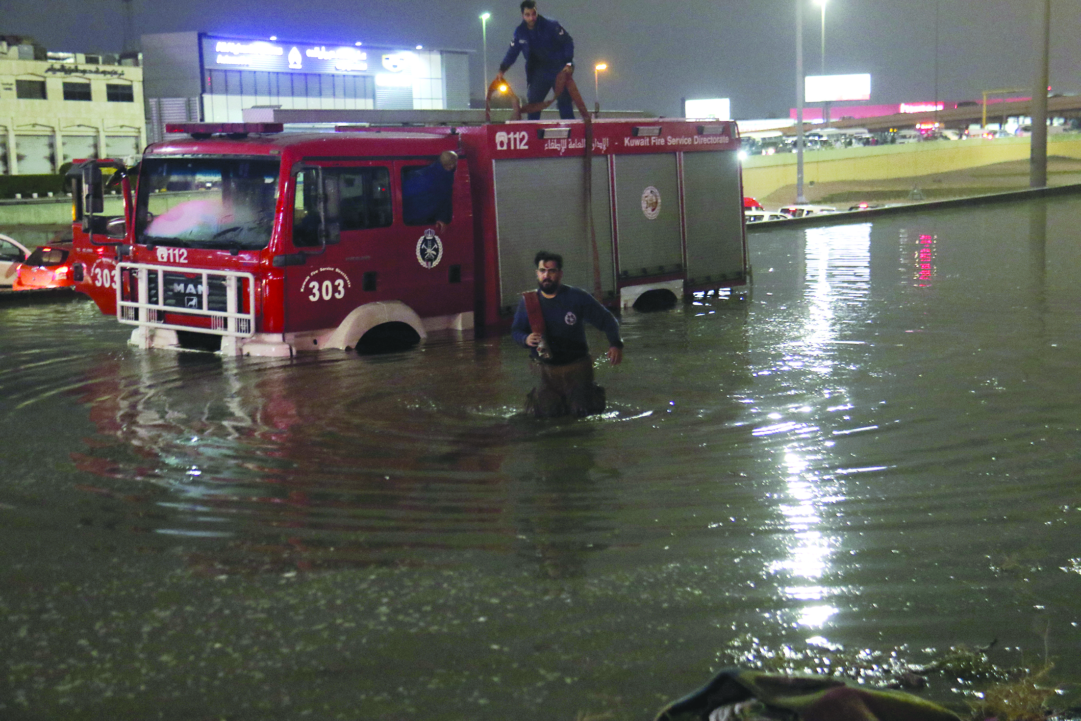 رجال الإطفاء يساعدون السيارات الغارقة في السيول                	     (تصوير بسام زيدان)