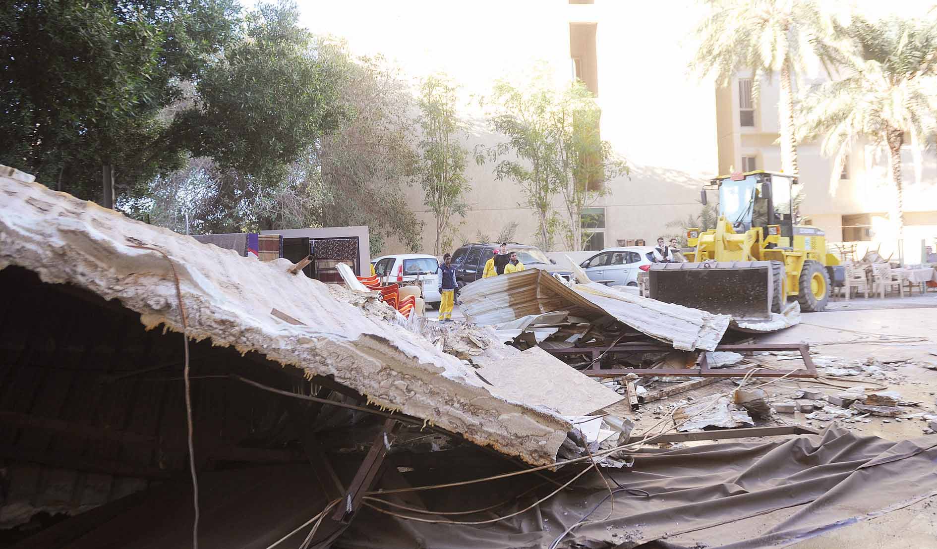 جرافة تزيل المظلات المخالفة