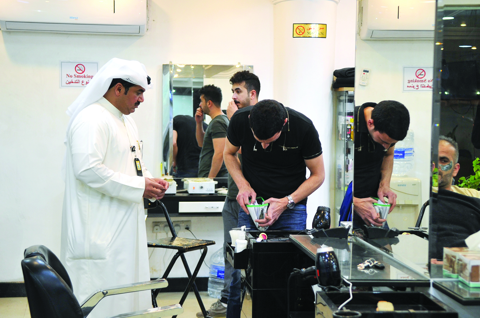 القعود يتأكد من البطاقة الصحية للحلاق 