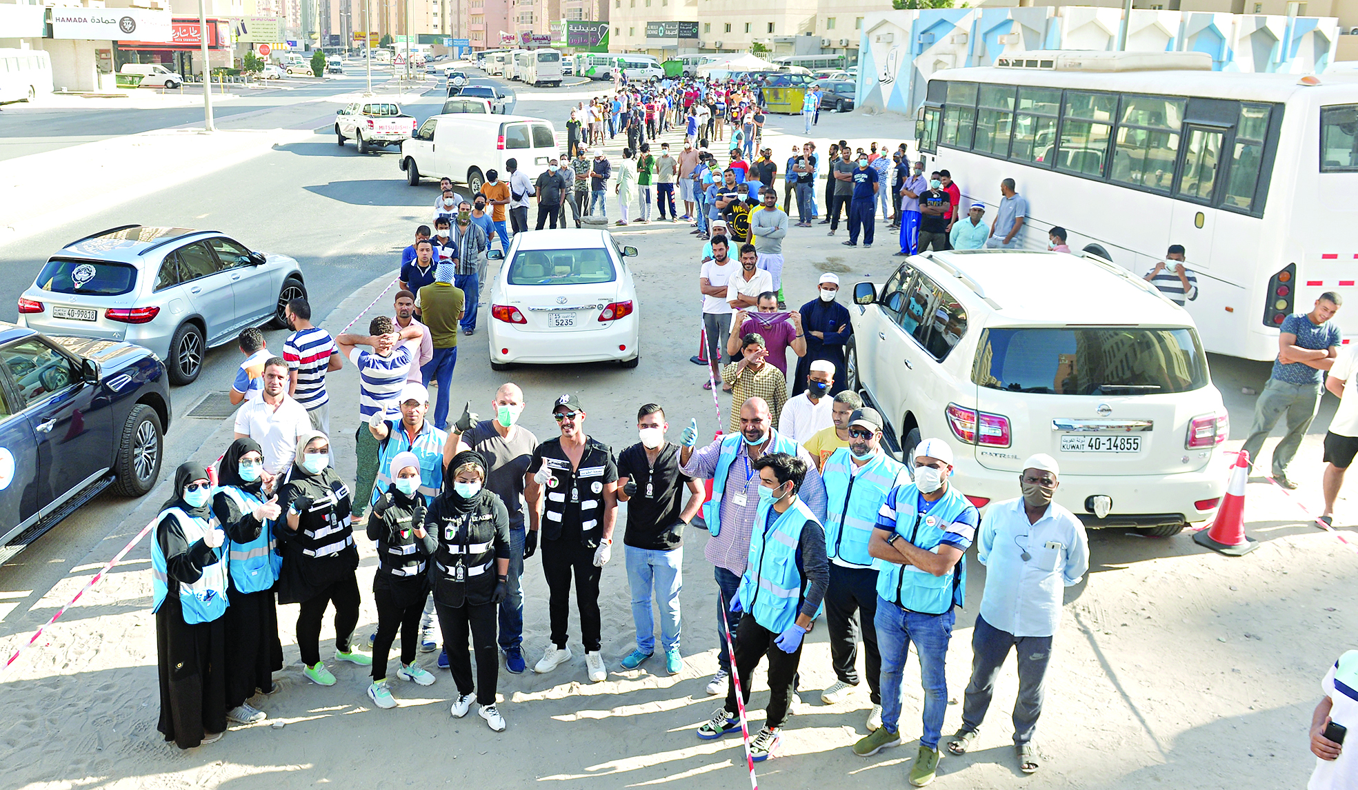 أعضاء الفريق التطوعي في لقطة جماعية بموقع توزيع وجبات الإفطار	 (تصوير أسعد عبدالله)