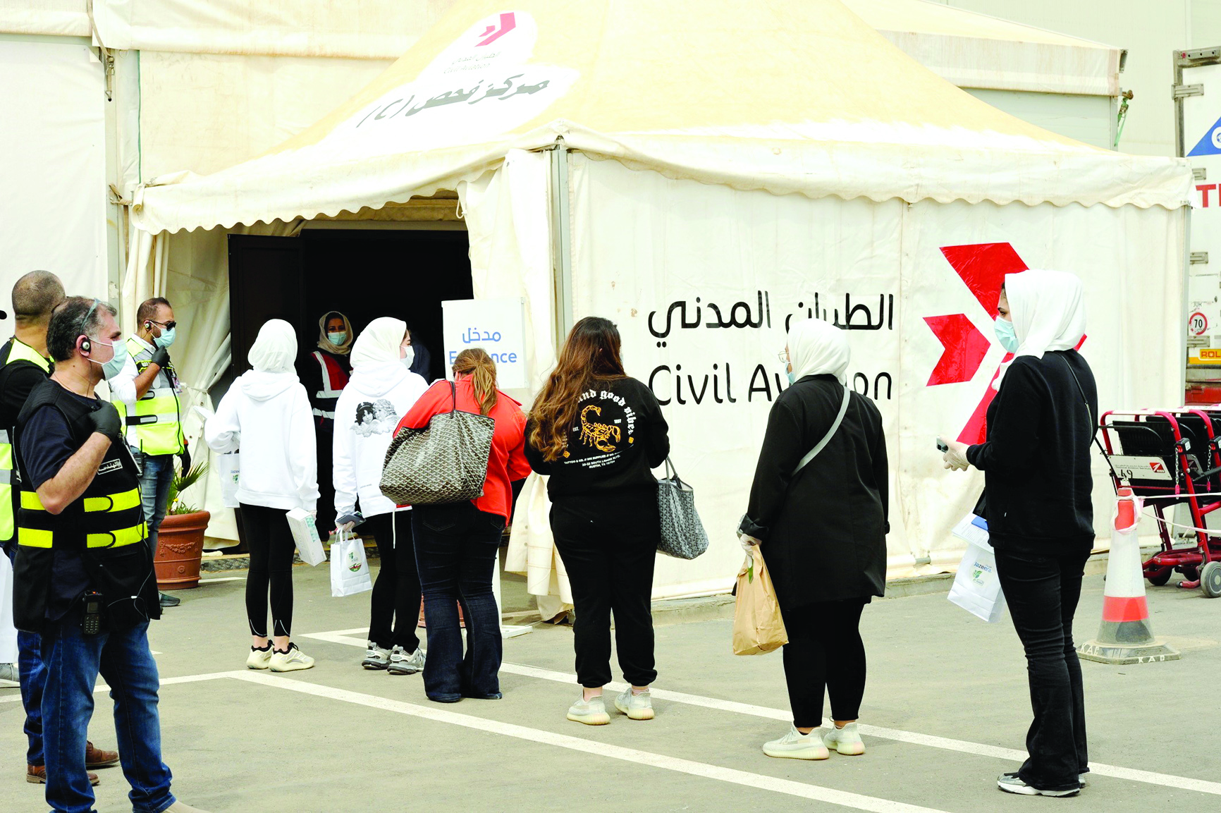 طالبات عائدات أمام مركز الفحص الطبي في المطار