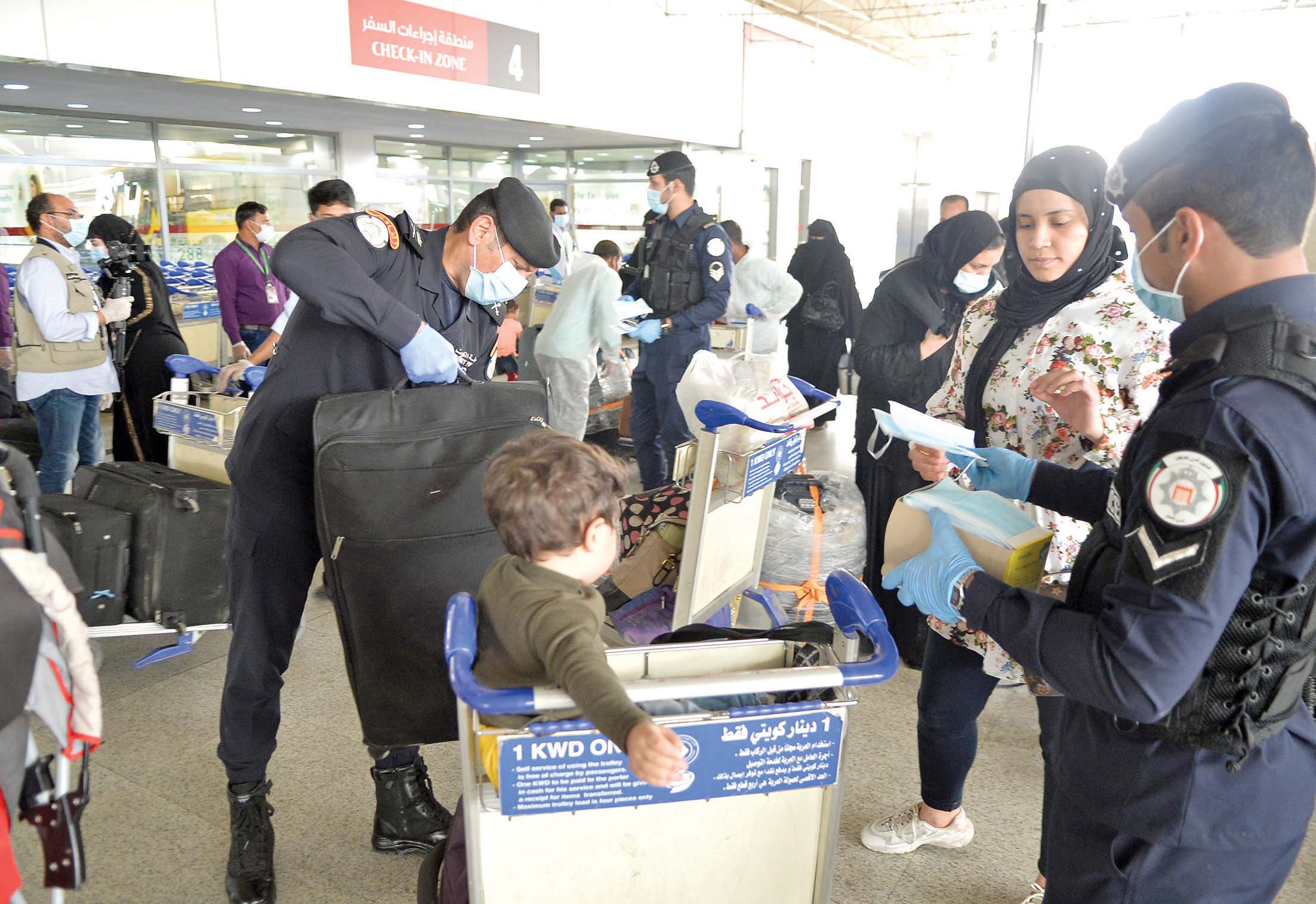 رجال الأمن يساعدون المسافرين على نقل الأمتعة
