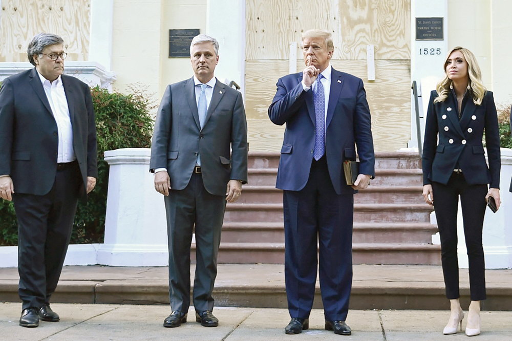 ... ويضع إصبعه على شفتيه وهو يقف أمام الأسقفية مع بار وأوبراين وماكيناني 	  (رويتزر)