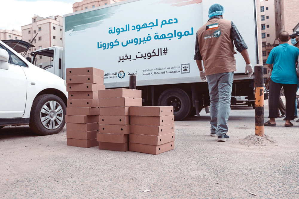 توزيع الوجبات على عمالة المناطق المعزولة بالكويت