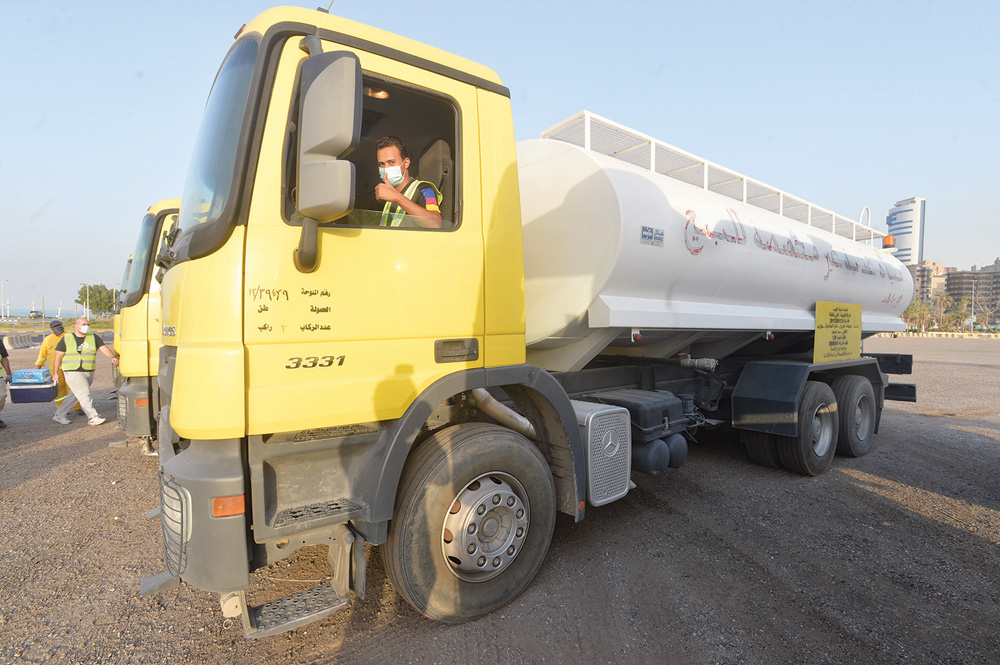 أحد المتطوعين يقود تنكر ري المياه