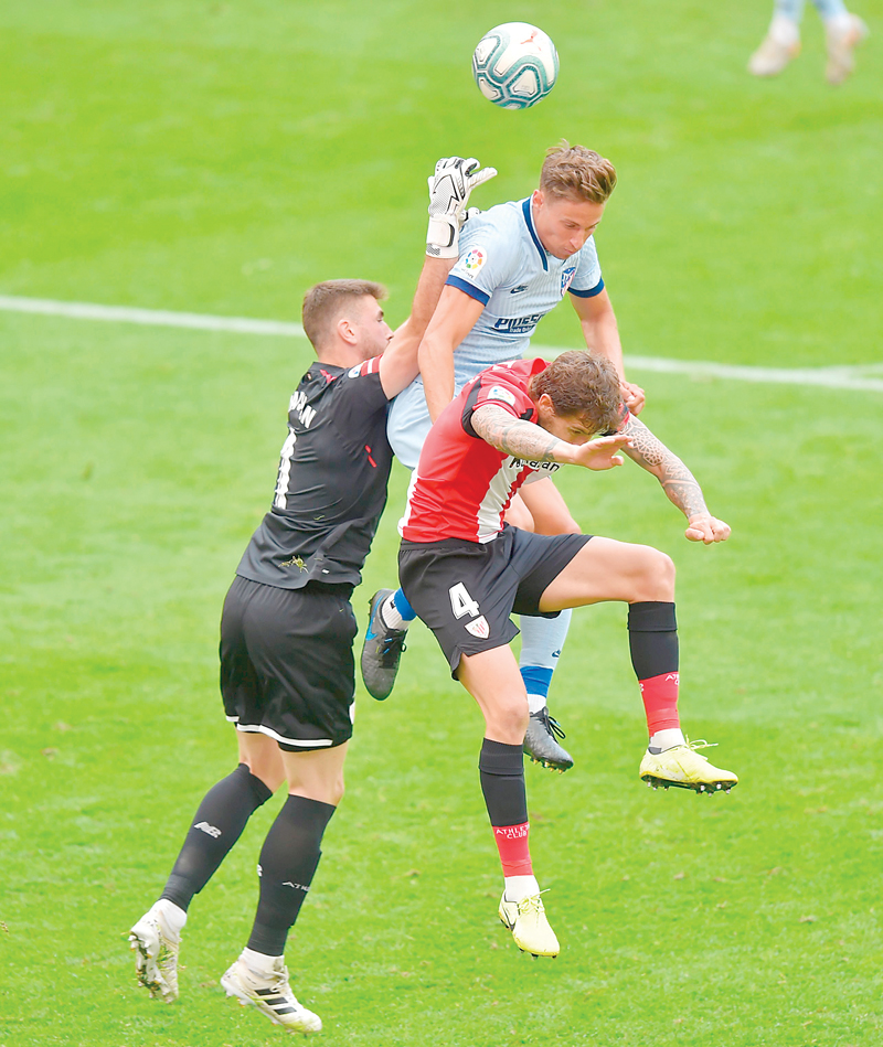 صراع «طائر» على الكرة خلال مباراة أتلتيكو مدريد وأتلتيك بلباو        	         (أ ف ب) 