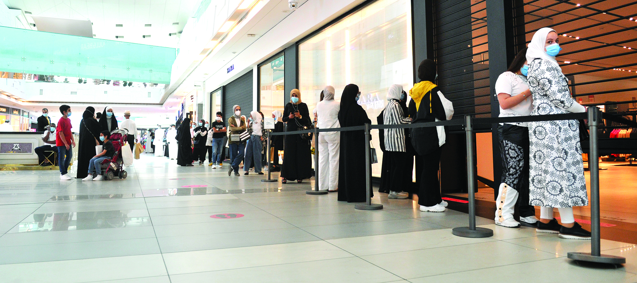 طابور متسوقين أمام أحد المحلات 