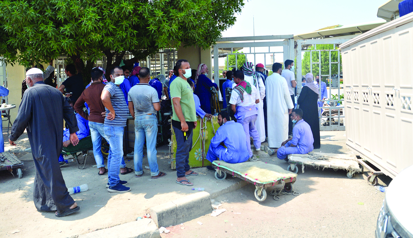 عمال ورواد ينتظرون أمام أحد الابواب