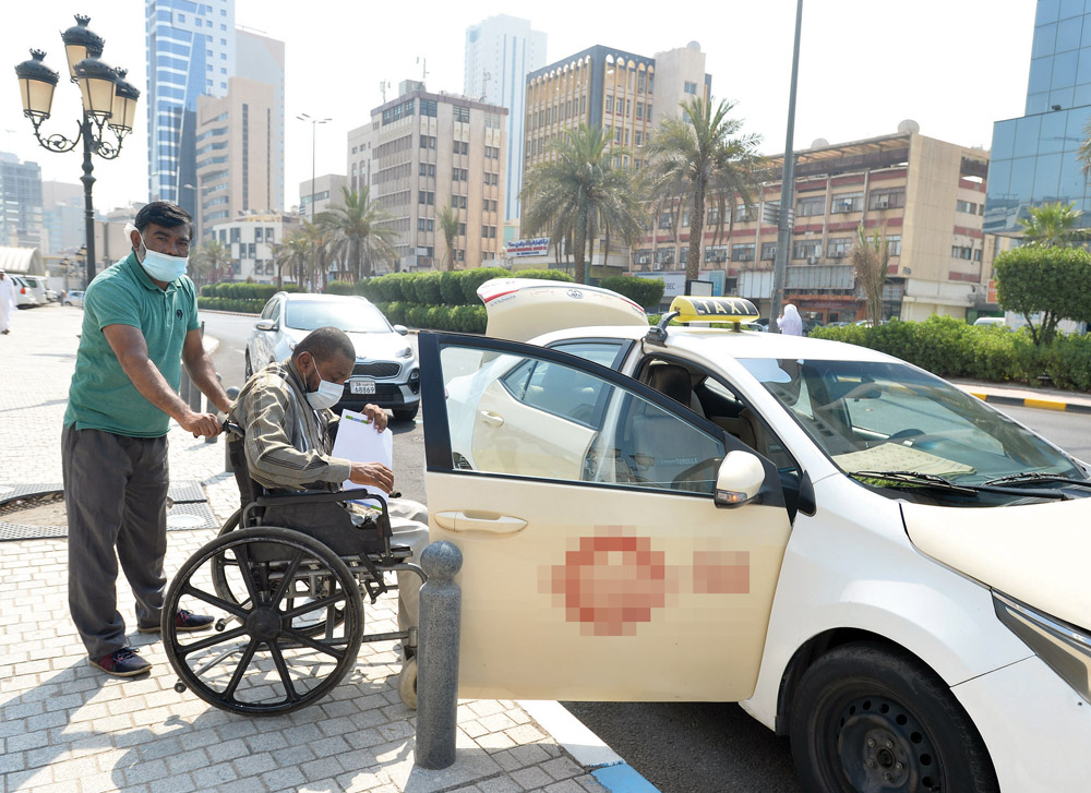 راكب على كرسي نقال... ماذا إذا كان مع مرافق؟!  	(تصوير أسعد عبدالله)
