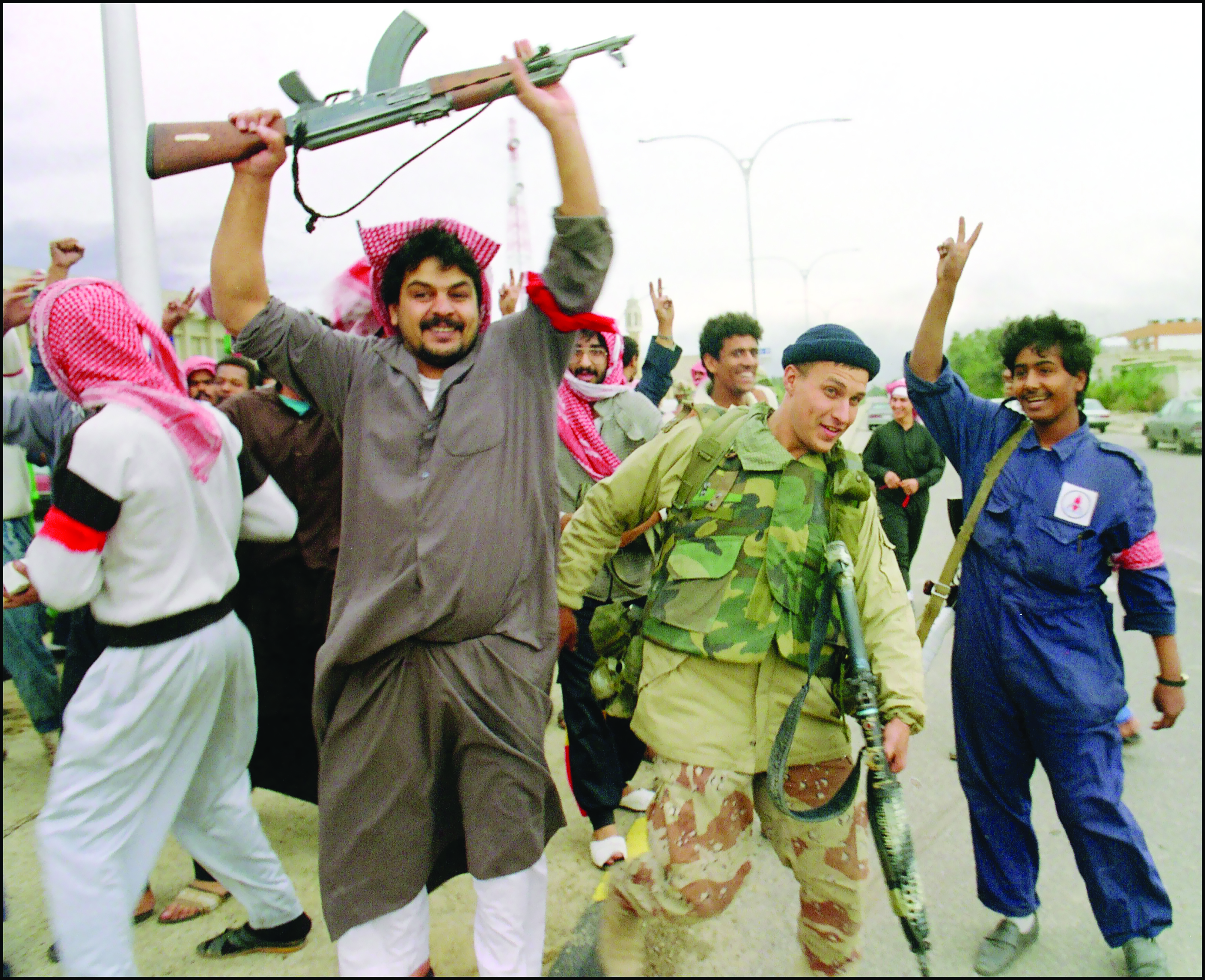 رجال المقاومة يحتفلون مع أحد أفراد القوات الأميركية بعد دخول قوات المارينز منطقة الصباحية