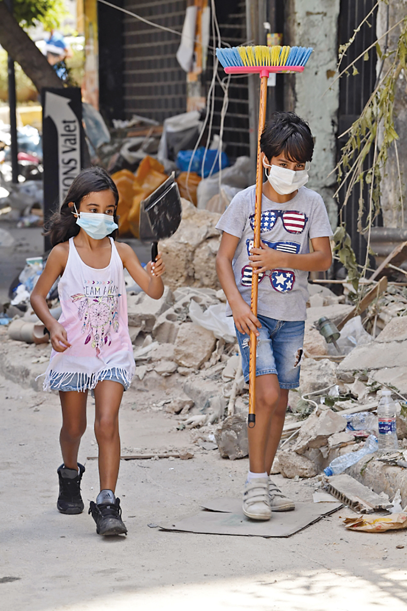 طفلان يساهمان في تنظيف ركام بيروت   	        (أ ف ب) 