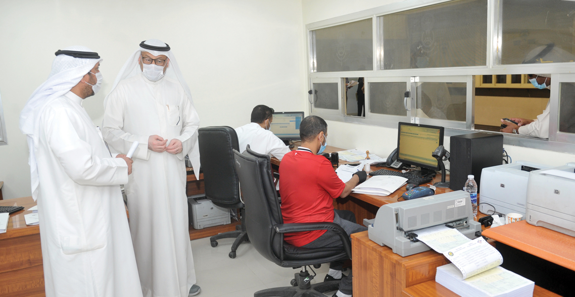 العنزي والزميل ناصر الفرحان في مكتب توثيق البيانات الجمركية	 (تصوير سعود سالم)