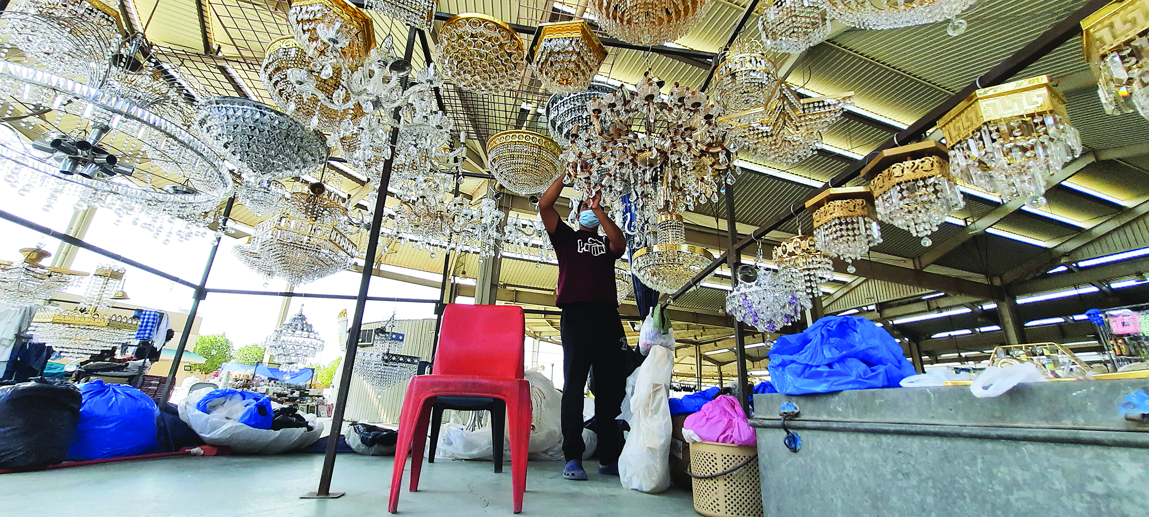 عامل يعلّق النجف وينظفه