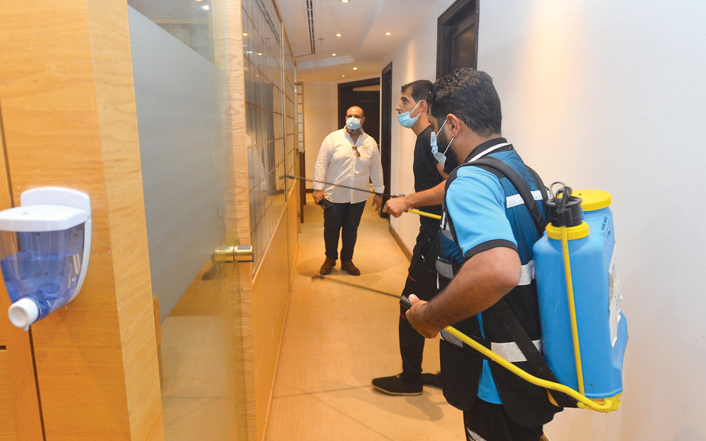 عدد من العمال يقومون برش المطهرات