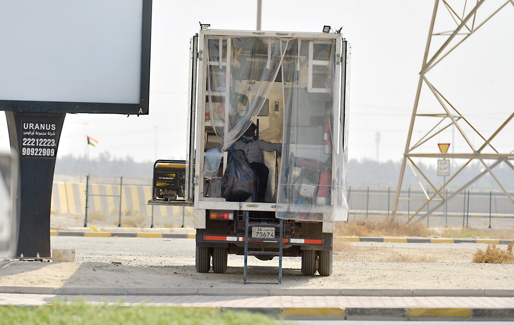بين الطريقين وعند عمود كهرباء