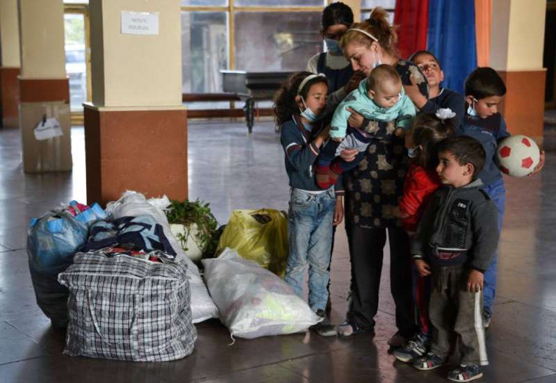 نازحة من كاراباخ مع أطفالها السبعة بجانب امتعتهم في مركز للاجئين في يريفان (أ ف ب)