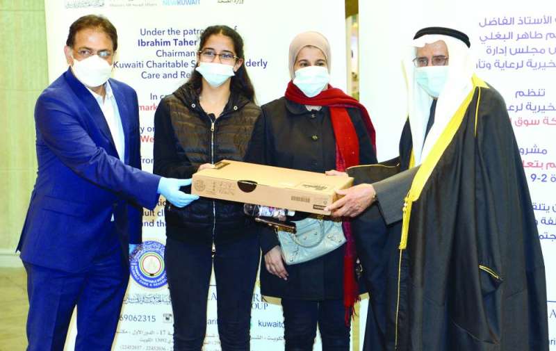 البغلي وممثل شركة لاند مارك يسلمان الهدايا لأسر المسنين