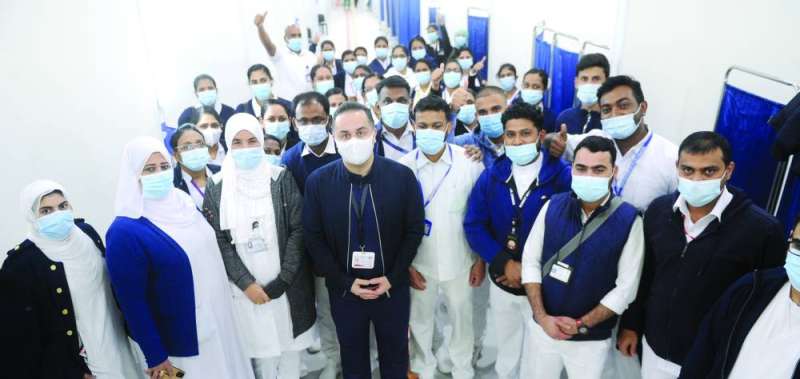 عبدالله السند يتوسط العاملين في المركز 	(تصوير سعود سالم)