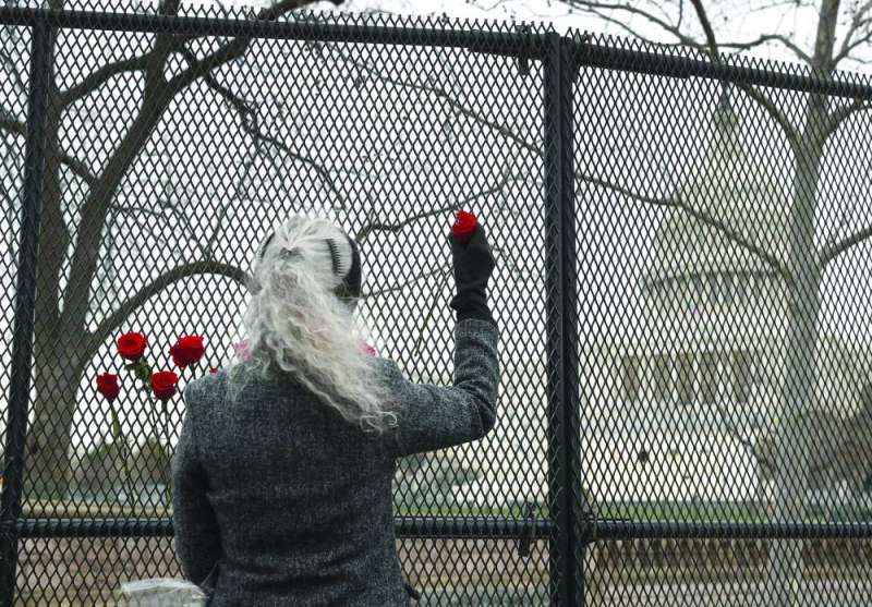 فتاة تضع الورود عند سياج مبنى الكابيتول في واشنطن 	(أ ف ب)