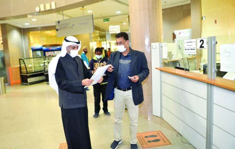 الحربي يطلع على معاملة أحد المراجعين	 (تصوير سعود سالم)