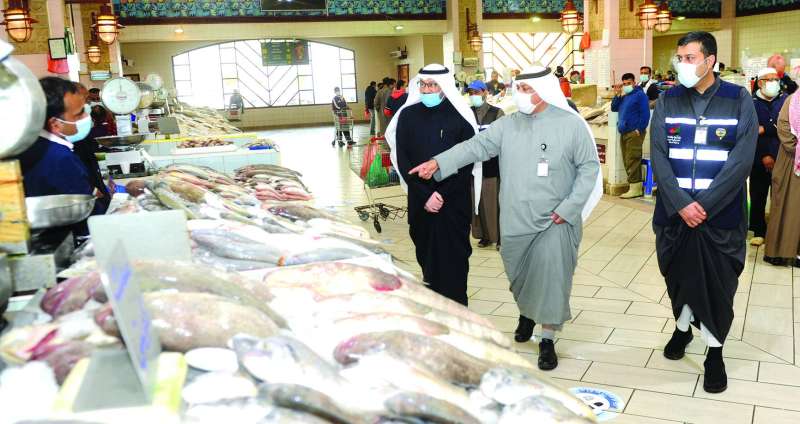 الرشيدي يشرح للزميل ناصر الفرحان فرق الأسعار بين الأسماك المحلية والمستوردة	(تصوير سعود سالم)
