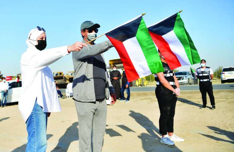 شباب فريق «كويتي بالقمة» يرفعون علم الكويت (تصوير نايف العقلة)