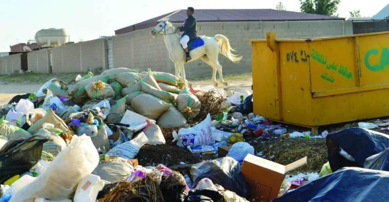أحد المواطنين يركب حصانا قرب تجمع نفايات في المنطقة