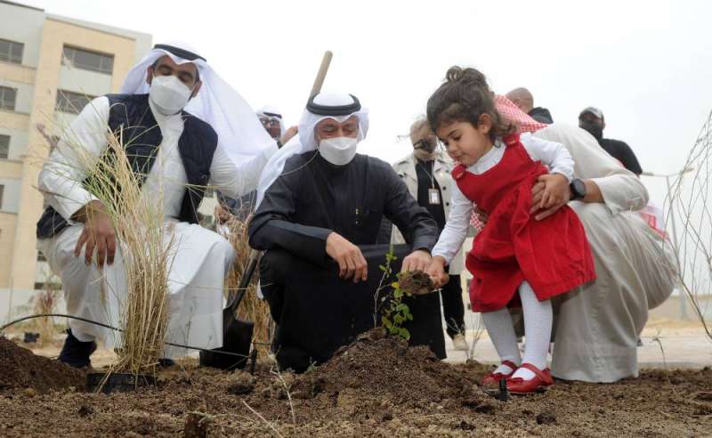 طفلة تساهم في غرس شجرة في جابر الأحمد بحضور الوزير معرفي (تصوير سعود سالم)