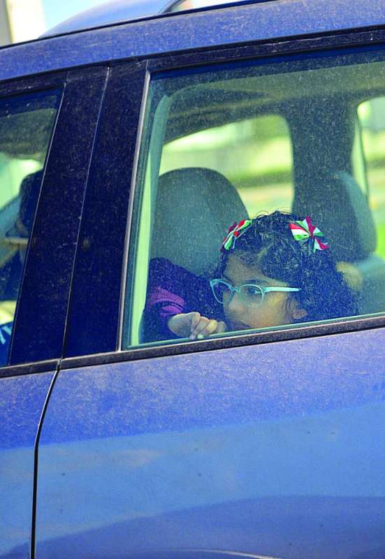 طفلة ترقب مظاهر الاحتفال من السيارة