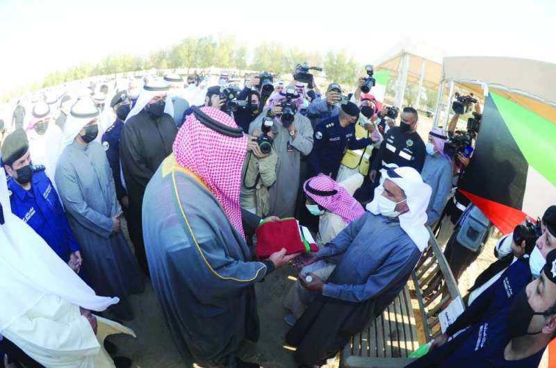 وزير الداخلية مسلماً علم الكويت لذوي أحد الشهداء	 (تصوير سعود سالم)