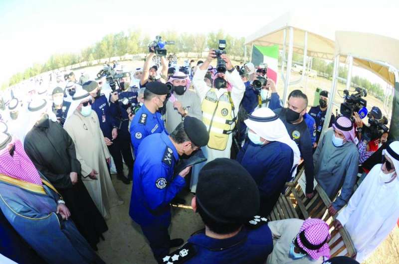 أحد الضباط يقبل علم البلاد قبيل تسليمه لذوي أحد الشهداء