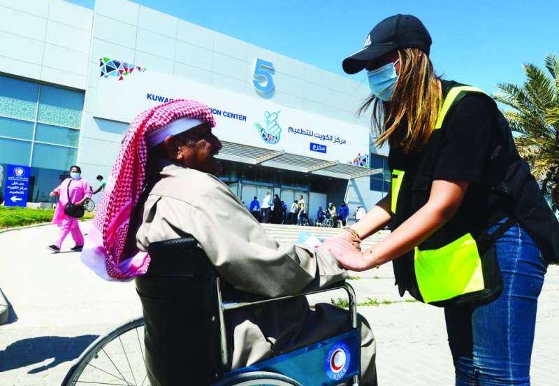 متطوعة تساعد أحد ذوي الحاجات الخاصة                                                                                                                             (تصوير أسعد عبدالله)