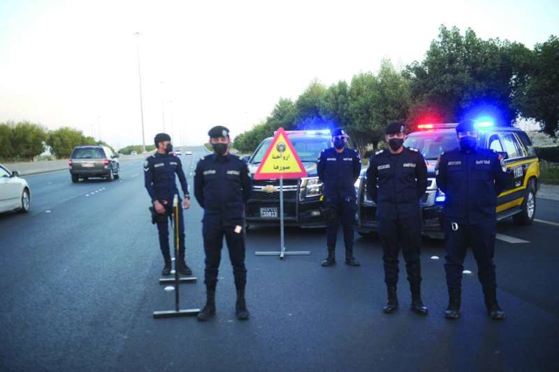 رجال أمن يستعدون لإقامة نقطة على أحد الطرق مع دخول وقت الحظر