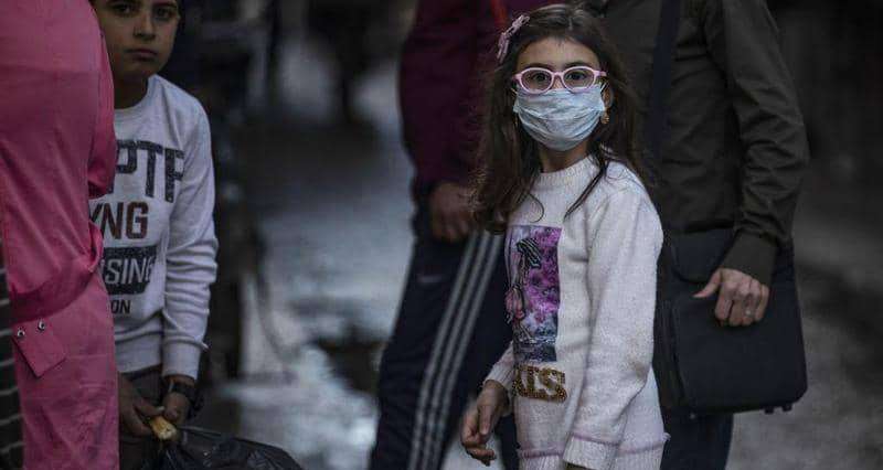 طفلة سورية ترتدي الكمامة