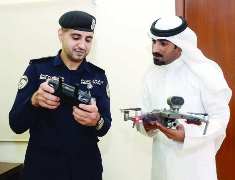 الرائد أبوحسن يوضّح للزميل نايف كريم طريقة عمل الـ «درونز» 	(تصوير أسعد عبدالله)