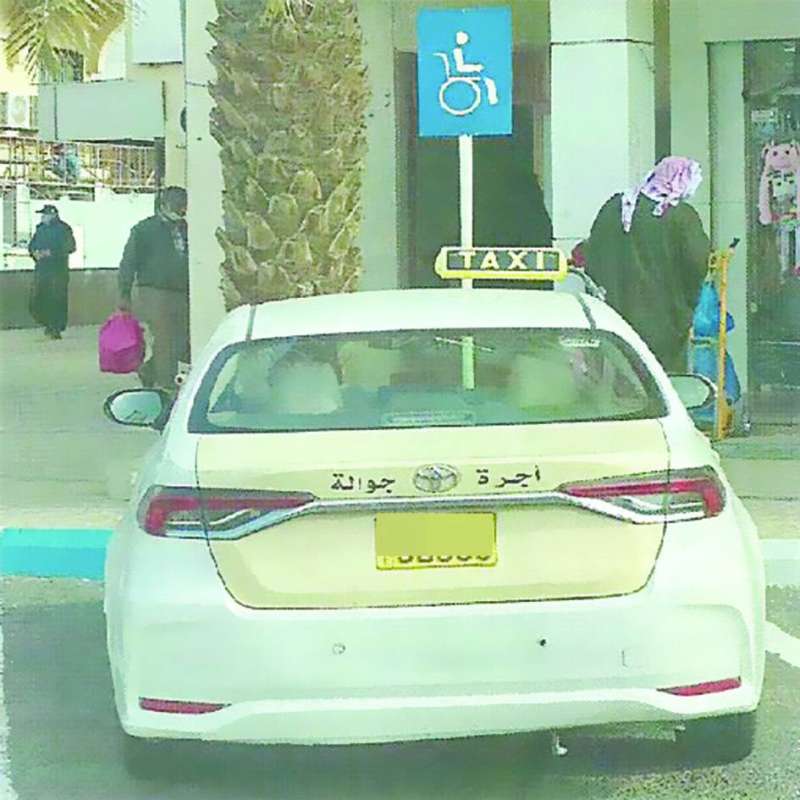 سيارة تاكسي تقف في أحد مواقف ذوي الاحتياجات الخاصة