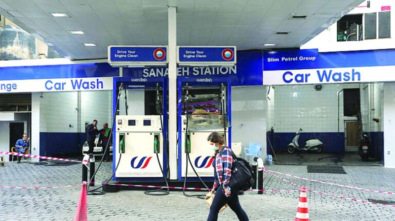 لبنانية تسير أمام محطة بنزين خارج الخدمة في بيروت