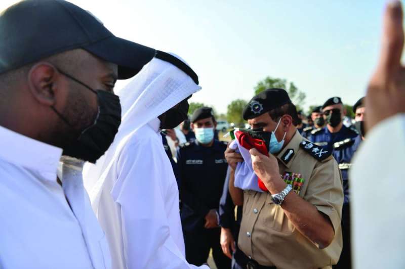 عصام النهام مقدماً علم الكويت الذي لفّ على الجثمان لذوي الشهيد	  (تصوير نايف العقلة)