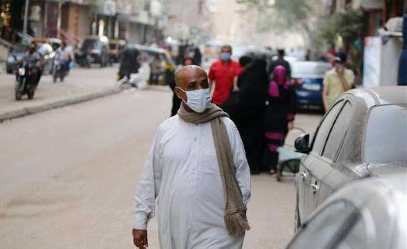 مصري يرتدي الكمامة في أحد شوارع القاهرة