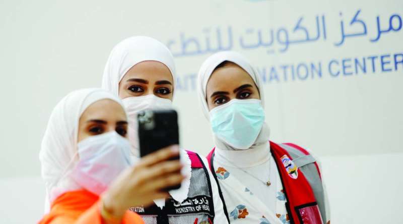 مراجعة تلتقط «سيلفي» مع اثنتين من كادر وزارة الصحة