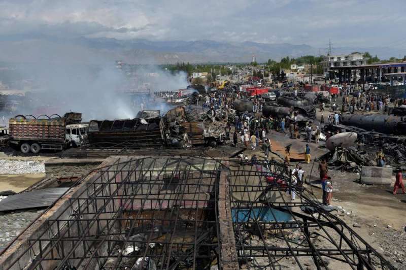 سكان محليون وملاك صهاريج وقود يتفقدون أضرار الحريق الليلي الضخم في منطقة قلعة مراد بك في ضواحي كابول أمس (أ ف ب)