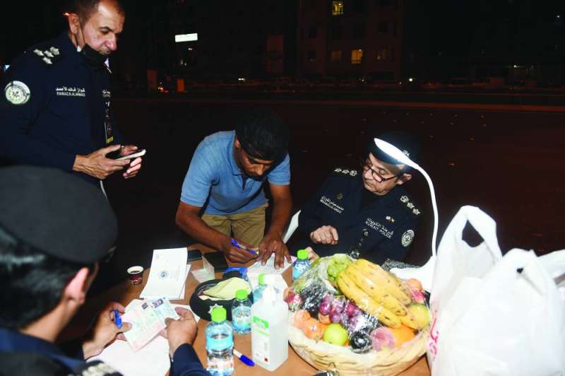 أحد الدراجين يوقع على الإقرار بالمخالفة أمام الشيرازي 	(تصوير أسعد عبدالله)