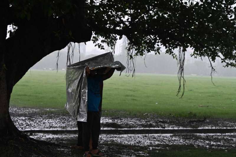 أشخاص يحتمون من الأمطار في كالكوتا