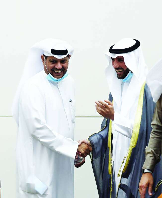 مصافحة وابتسامة مشتركة بين الغانم والديحاني إثر رفع الجلسة	 (تصوير أسعد عبدالله) 