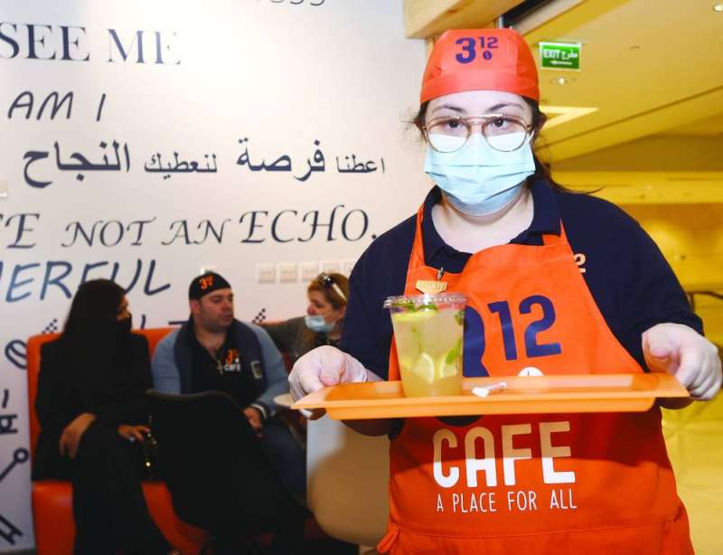 موظفة من ذوي الاحتياجات الخاصة تتابع طلبات الزبائن
