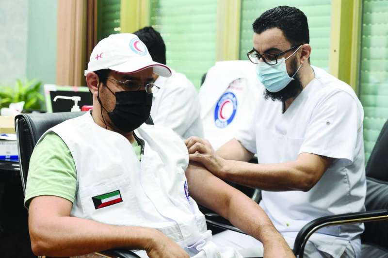 تطعيم أحد العاملين في «الهلال الأحمر» 	(تصوير أسعد عبدالله)
