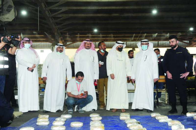 
قياديو الجمارك مع الزميل ناصر الفرحان وأمامهم المضبوطات 	(تصوير سعود سالم)
