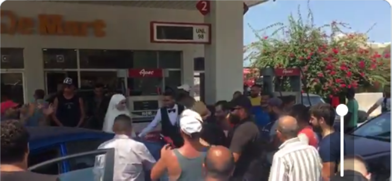 صورة لعريس يقوم بتعبئة البنزين لسيارة الزفاف وبجانبه عروسه في القلمون شمال لبنان