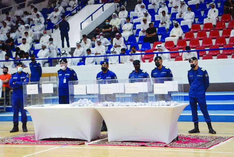 صناديق القرعة أمام رجال الإطفاء وخلفهم الطلبة يتابعون مجريات القرعة 	(تصوير نايف العقلة)